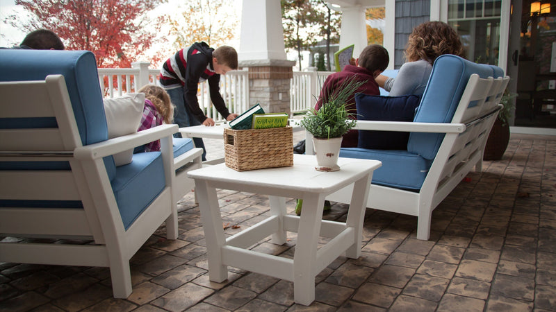 A family sits out on a brick patio on a POLYWOOD Harbour 5 Piece Deep Seating Set in White and Sky Blue.