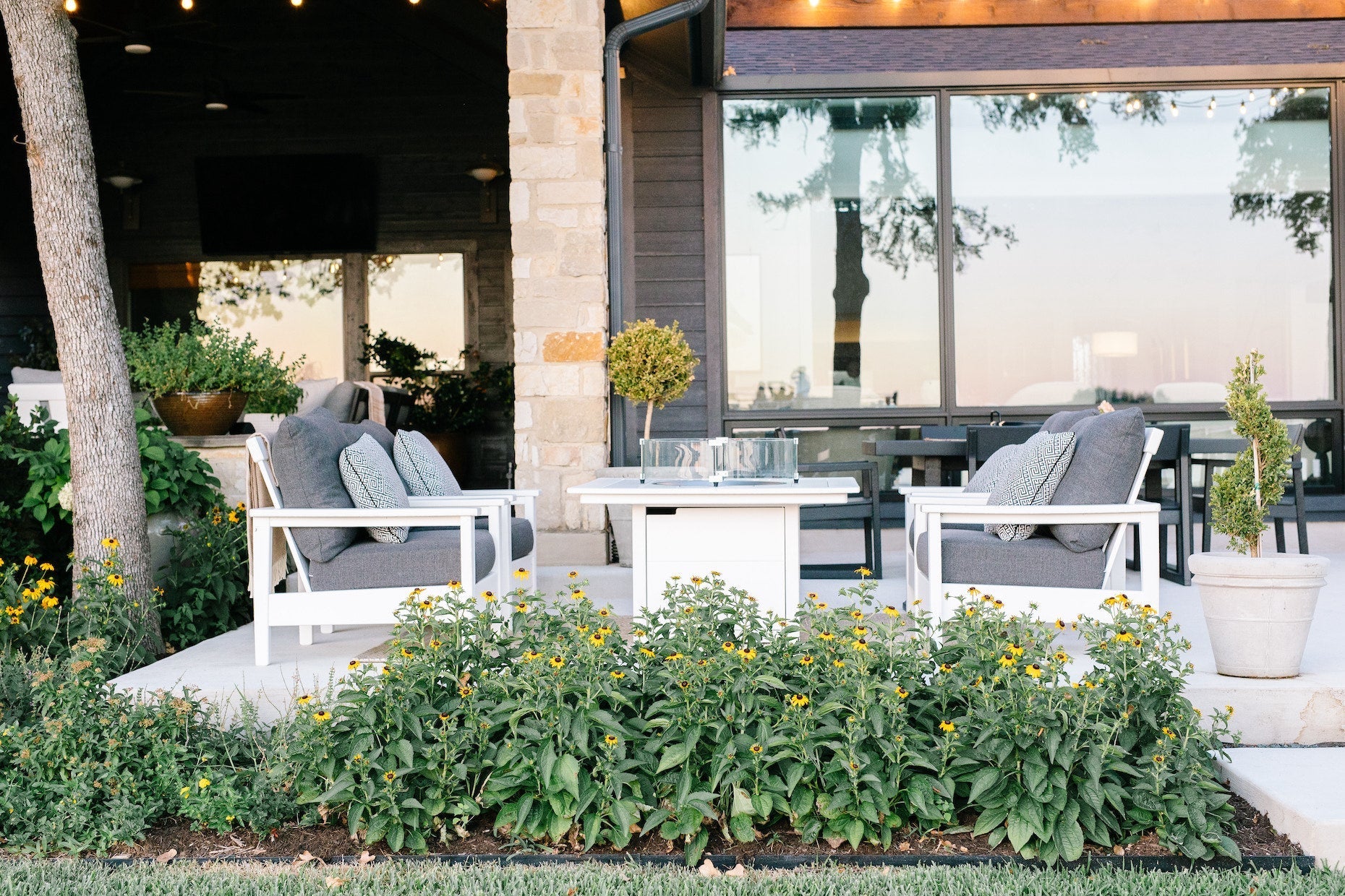 POLYWOOD Prescott Deep Seating Chairs in White and Grey Mist surround a Square 42 Inch Fire Pit Table in White on a patio.