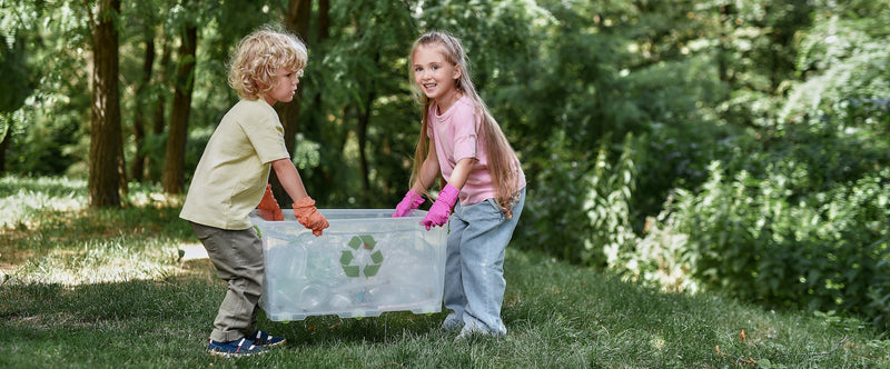 Children carry a recycling bin filled with empty plastic bottles.