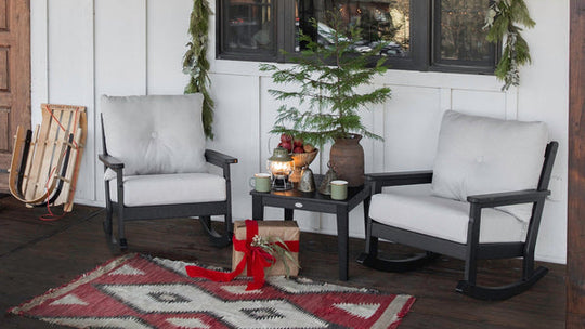 A POLYWOOD Vineyard 3-Piece Deep Seating Rocker Set in Black and Natural Linen sits on a rustic porch with holiday decor. 