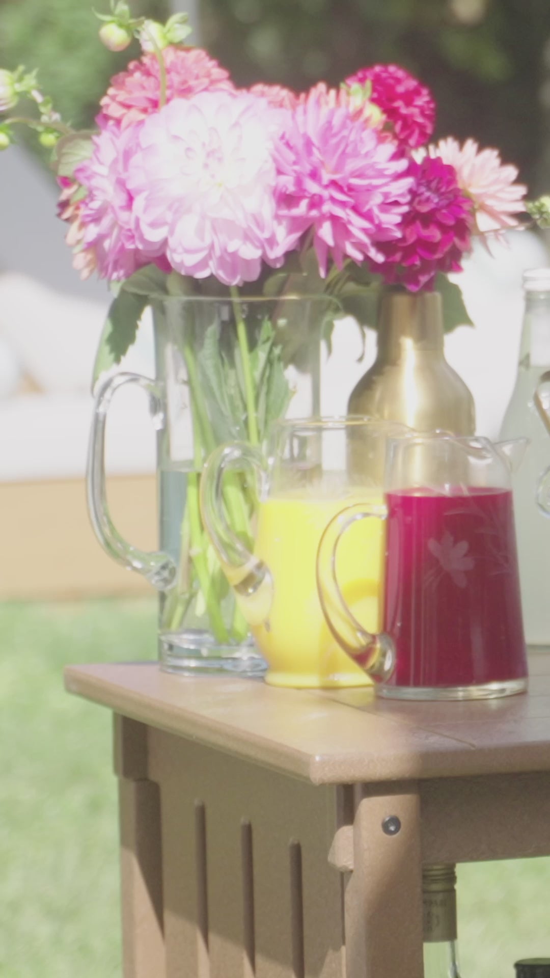 Chef Alex Guarnaschelli mixes a cocktail on a brown POLYWOOD Vineyard Bar Cart and takes a sip of the pink drink.