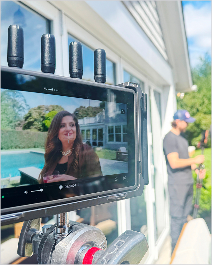 A camera records chef Alex Guarnaschelli near a pool and POLYWOOD outdoor furniture during a photo shoot.